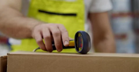 Close up of warehouse worker putting barcode scanner on box and leaving Stock Photos