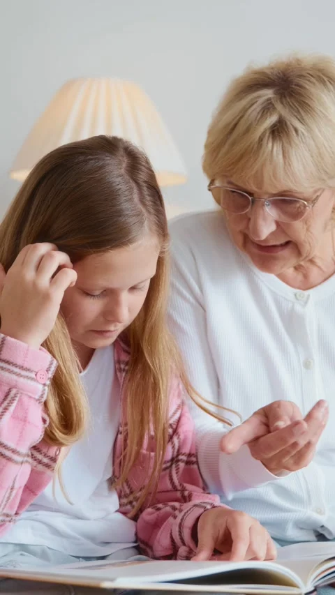 Close up of a warm reading moment between grandmother and granddaughter Stock Footage 315558056