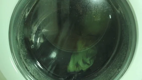 Close Up of the wash cycle of a high-efficiency front-loader washing machine Stock Footage 92483491