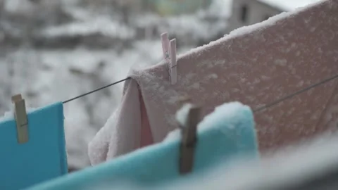 Close-up of washed clothes hanging on a clothesline outdoors in snowy winter. Dr Stock Footage 263664918