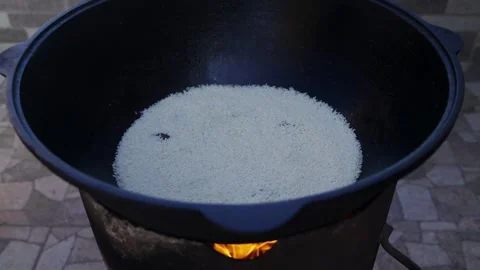 Close-up of washed rice in large cauldron for Uzbek pilaf over wood fire Stock Footage 333038494
