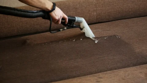Close-up of washing cleaner cleans the sofa and removes dirt, professional Stock Footage 124734288