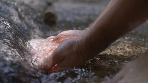 Close up on washing hands and face in in a stream in slow motion Stock Footage 91709935