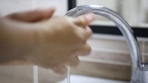 Close up of washing hands with soap under running water at bathroom sink Stock Footage 102862889