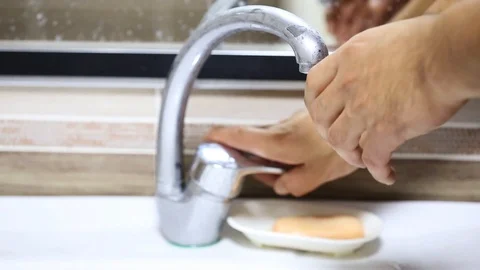 Close up of washing hands with soap under running water at bathroom sink Stock Footage 102862978