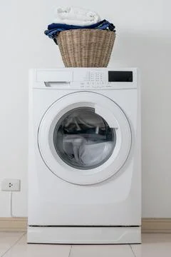 Close up washing machine and clothes in basket on white background. Laundry.. Stock Photos