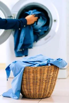 Close up washing machine and clothes in basket on white background. Laundry.. Stock Photos