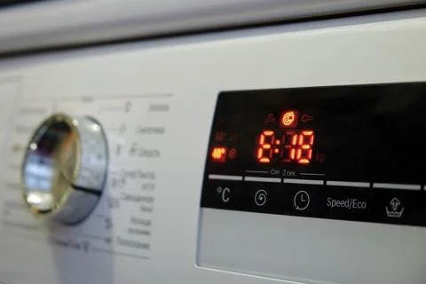 Close-up of a washing machine control panel with a digital display and a er.. Stock Photos