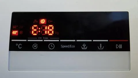 Close-up of a washing machine control panel with a digital display and a er.. 스톡 사진