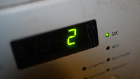 Close-up of washing machine panel showing bright green number two Stock Footage 330254764