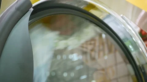 Close up to washing machine washes laundry colored clothing and sheets wash.. Stock Footage 232396828