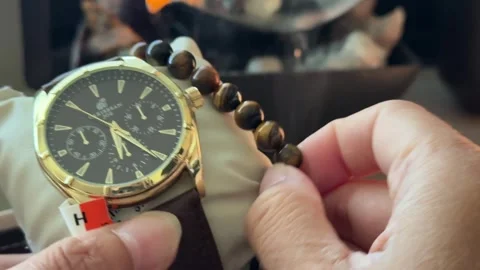 Close Up Of A Watch and Tiger Eye Bead Bracelet with White Smoke Stock Footage 336590794