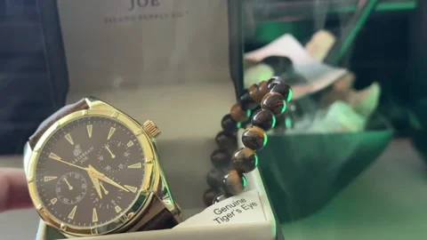 Close Up Of A Watch and Tiger Eye Bead Bracelet with White Smoke Stock Footage 336590836