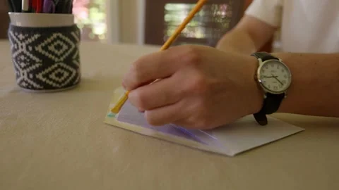 Close up of water being applied to envelope seal with brush. Stock Footage 142845774