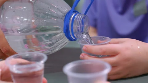 Close-Up of Water Being Poured into Cups for Hydration After Workout Vidéo 305002629