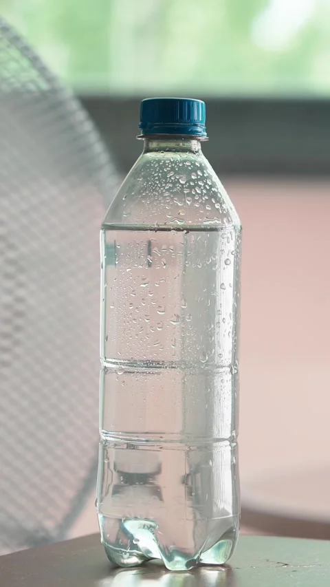Close up of water bottle in front of floor fan Stock Footage 342990249