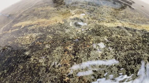 Close-up of water bubbling up from a dark textured stone fountain-9 Stock-Footage 345936781