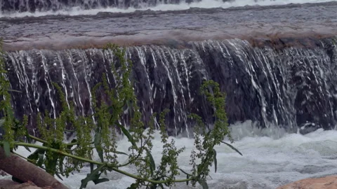 Close Up of Water Cascading Over Small River Dam Stock Footage 336221707