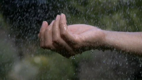Close up of Water Dripping Down onto an Outstretched Clenched Hand that Opens Stock Footage 270386946