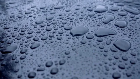 Close up of water droplets on dark reflective surface Video stock 333835454