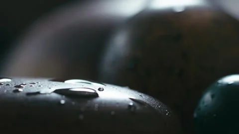 Close-up of water droplets falling onto an agate stone. Stock Footage 345567883