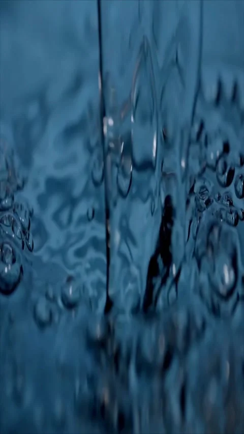 Close-up water droplets flowing down glass surface Stock Footage 339779044