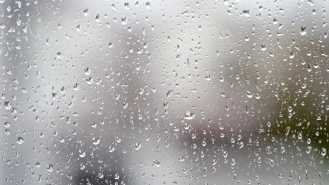 Close-up of water droplets on glass. Large rain drops strike a window pane. 4K. Stock Footage 176562889