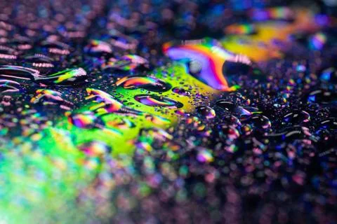A close-up of water droplets on a reflective surface, creating bright. Stock Photos