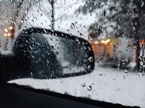 Close-Up Of Water Droplets On Side Window Of Car During Snowfall In Winter Stock Photos