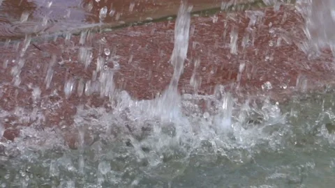 Close-up of water drops that fall on the granite stone in the city fountain.  Video stock 111423036