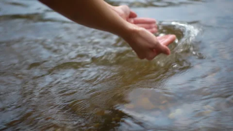 Close-up water drops falling down from woman hand at river in mountains forest.  Stock Footage 265203585