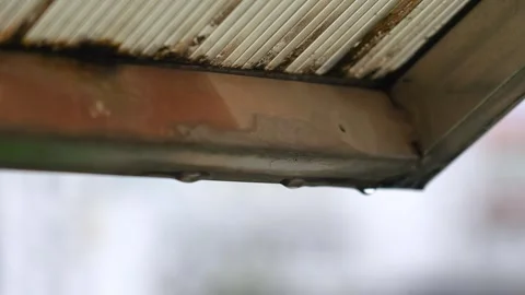 Close-up of water drops falling slowly from the edge of the eaves after the rain Stock Footage 340210787