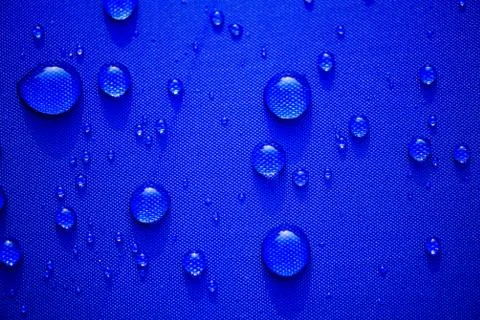 Close up Water drops pattern over a blue waterproof cloth background. World W 写真素材