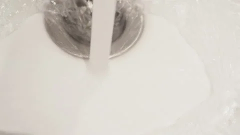Close-up of water falling down the bathroom sink drain Stock Footage 143221449