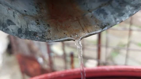 Close-up of Water Flowing from Metal Gutter into Barrel During Rain Vídeo Stock 333642432