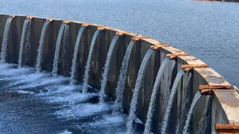 Close-up of a water flowing over concrete barrier. Row of thin trickles. Stock Footage 291228768