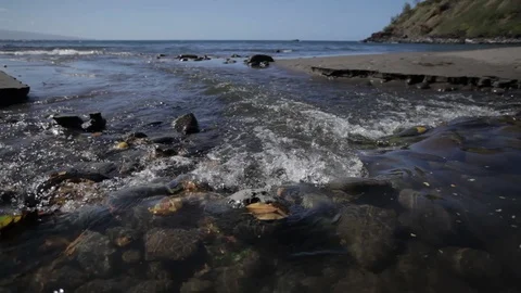 Close up on water flowing over rocks in a tropical cove Hawaii Stock Footage 90943121
