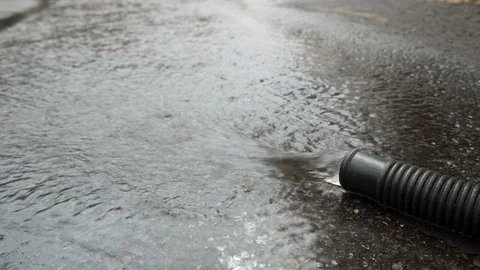Close Up of Water Flowing from a Pipe, Hose, on Asphalt, 4k Stock Footage 107952491