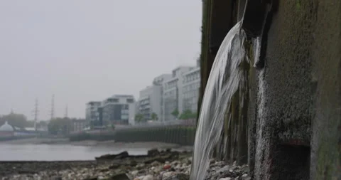 Close Up of Water Flowing into the River Thames from a Drainage Pipe Stock Footage 291099411