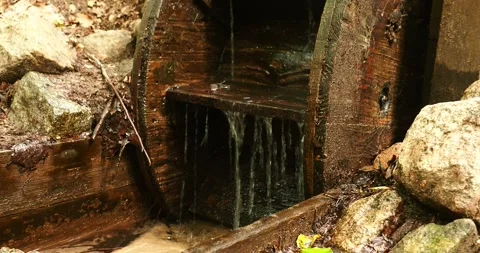 Close-Up of Water Flowing Through a Rustic Wooden Water Wheel Video stock 339094069
