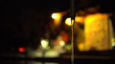 Close-up, water flows from the hose, on a dark blurred background. The Stock Footage 92802423