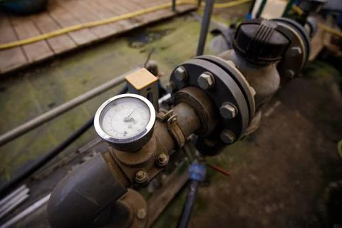 Close up of water pressure sensor or manometer with pipes and valves. Industr Stock Photos