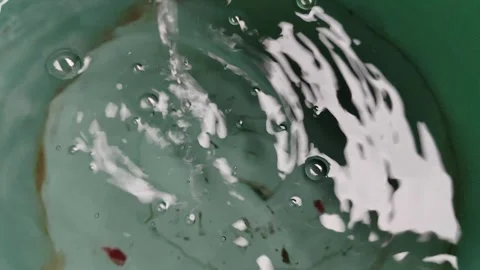 Close-Up of Water Ripples and Bubbles in a Calm Green Basin Stock Footage 311514730