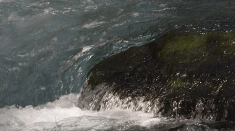 Close-up water sluicing over a rock in a river Stock Footage 59528090