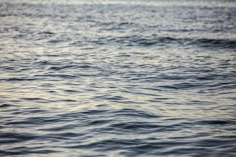 Close-up of water surface, dark waves on the sea during sunset Foto stock