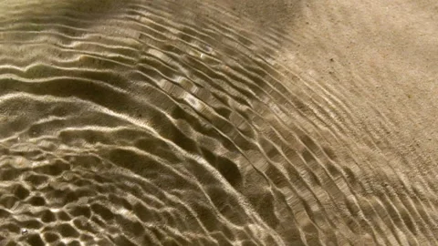 Close-up water surface ripples and splash, palm tree leaf shadow on sand texture Stock Footage 249649099