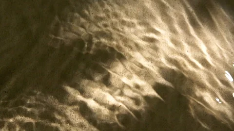 Close-up water surface ripples and splash, palm tree leaf shadow on sand texture Vídeo Stock 255421312