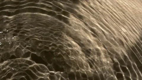 Close-up water surface ripples and splash, palm tree leaf shadow on sand texture Stock Footage 321444704