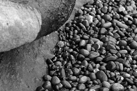 Close up of water trickling over smooth, multicolored pebbles Stock Photos