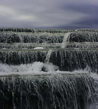 Close-up waterfall on the background of the cloudy sky. Stock Photos